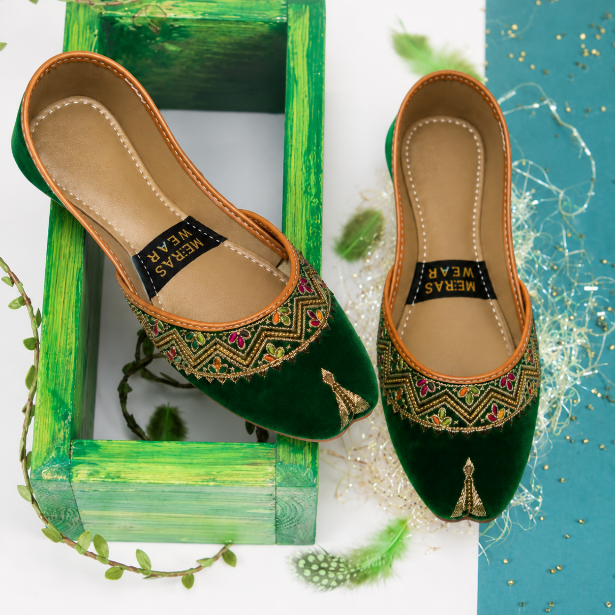 Top view of green velvet khussa pair with golden embroidered floral detailing.
